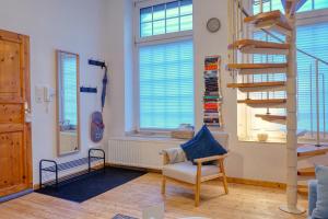 ein Wohnzimmer mit einer Treppe und einem Stuhl in der Unterkunft No.1 by 21Apartments in Krefeld