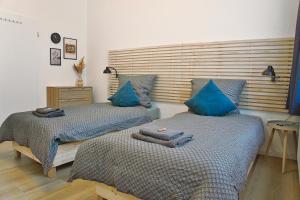 two beds with blue pillows in a bedroom at No.1 by 21Apartments in Krefeld