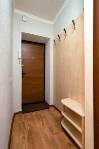 a hallway with a wooden door and a wooden floor at Nadezhda Apartment on Abay Avenue 59 in Almaty