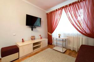sala de estar con TV de pantalla plana y ventana en Nadezhda Apartment on Abay Avenue 59 en Almaty