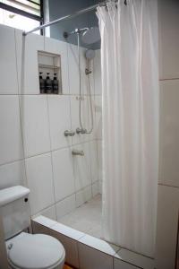 a bathroom with a shower curtain and a toilet at Kai Dou in Roseau