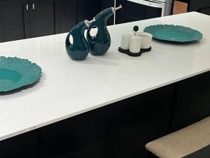 a counter with two green plates and two white candles at Kai Dou in Roseau +7 photos