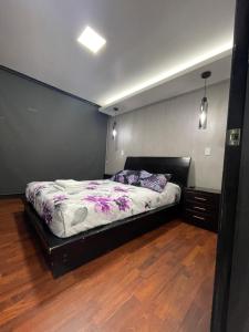 een slaapkamer met een bed en een houten vloer bij ItsaHome Apartments - Torre Aqua in Quito