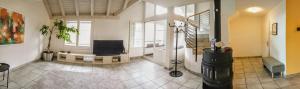 una gran sala de estar con TV y una escalera en Aquae Helveticae en Baden