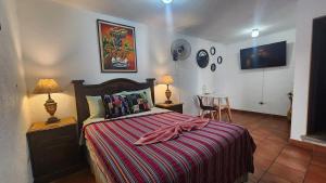 1 dormitorio con 1 cama y 1 mesa con sillas en MAGNOLIAS, en Antigua Guatemala