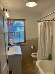 a bathroom with a tub and a sink and a toilet at Spacious home in downtown White Sulphur Springs in White Sulphur Springs