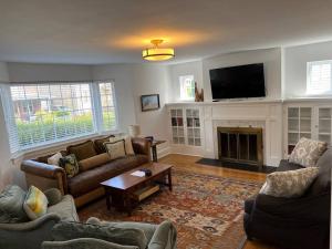 a living room with couches and a tv and a fireplace at Spacious home in downtown White Sulphur Springs in White Sulphur Springs