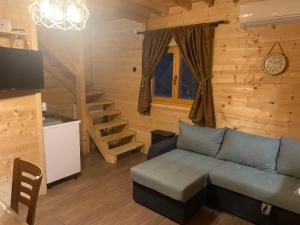 a living room with a blue couch in a cabin at Suncev Brijeg in Banja Luka