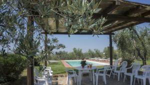 un patio con mesa, sillas y piscina en Agriturismo Sommassa, en Greve in Chianti