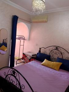 a bedroom with a bed with purple sheets and a window at Majorelle Family Residence Medina in Marrakech