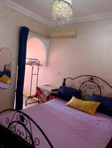 a bedroom with a bed with purple sheets and a window at Majorelle Family Residence Medina in Marrakech