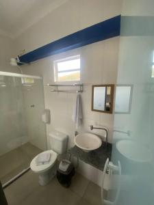 a bathroom with a white toilet and a sink at Pirai Hotel Fazenda in Piraí