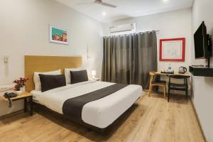 a bedroom with a large bed and a desk at Super Townhouse 176 Rajdhani Residency in Surūrnagar
