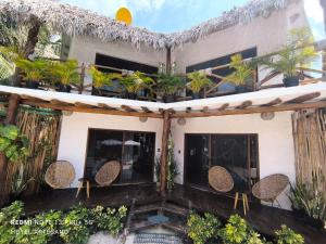 ein Haus mit Stühlen und Pflanzen auf dem Balkon in der Unterkunft Arte Sano Hotel - Adults only in Holbox
