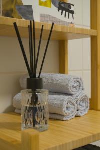 a glass vase with sticks in it on a table with towels at No2 by 21 Apartments in Kaarst