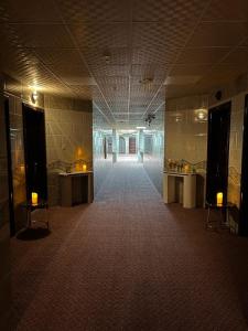un couloir vide dans un bâtiment avec deux tables dans l'établissement غزالي للوحدات السكنية, à Médine