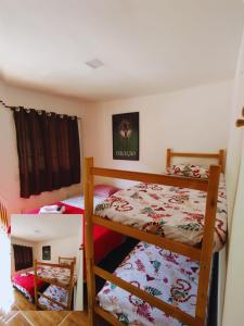 Refugio Do Paraty Mirim في باراتي: سريرين بطابقين في غرفة صغيرة مع سرير