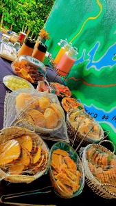 einen Tisch mit Körben mit Speisen und Getränken in der Unterkunft Refugio Do Paraty Mirim in Paraty