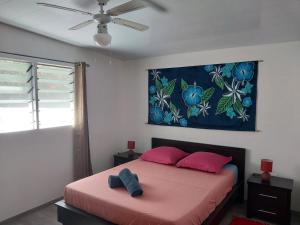 法赫的住宿－Le spot，卧室配有粉红色的床,墙上挂有绘画作品