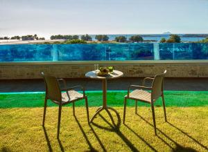 einen Tisch und zwei Stühle auf dem Rasen in der Unterkunft Dream Sea House villa Falassarna in Phalasarna