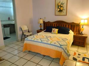 a bedroom with a bed and a chair and a fireplace at Casa Gaviotas Art cozy 2 bed house with art studio close to downtown in La Paz