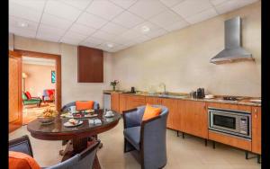阿布達比的住宿－Al Raha Beach Hotel - Deluxe Gulf Room SGL - UAE，一间厨房,内设桌子和椅子
