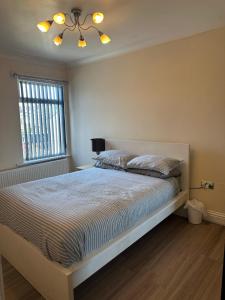 Un dormitorio con una cama y una lámpara de araña en Leavesden Residence - Central - Cosy - Harry Potter, en Leavesden Green