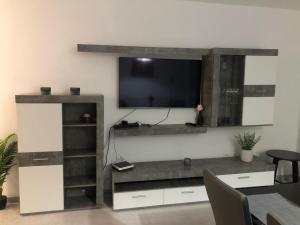 a entertainment center with a flat screen tv on a wall at Apartamento en Victoria Park Playa San Juan in Playa de San Juan