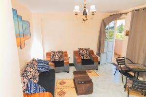 a living room with two couches and a table at Cosy 1-bedroom Hideout outside the city limits in Ruiru
