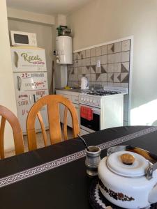 a kitchen with a stove and a table with a tea kettle at Amplio departamento, la mejor ubicación en Mendoza in Mendoza