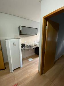 een badkamer met een wastafel en een witte koelkast bij Edifício Gervásio in Goiânia