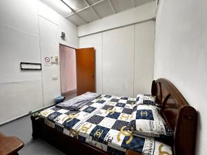a bedroom with a bed with a quilt on it at Jiaxin Dormitory - Puteri Wangsa 家馨旅舍 in Ulu Tiram