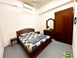 a bedroom with a bed and a dresser and a mirror at Jiaxin Dormitory - Puteri Wangsa 家馨旅舍 in Ulu Tiram