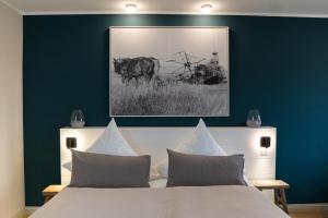 ein Schlafzimmer mit einem Bett mit einer blauen Wand in der Unterkunft Ferienanlage Landliebe Appartement 5 in Alkersum