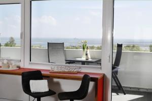an office with a desk and chairs and a window at Tief 10 „Meerblick Deck 9“ in Wangerland
