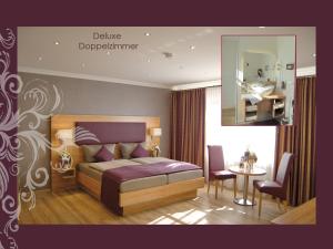 a bedroom with a bed and a table and a mirror at Hotel-Landrestaurant Schnittker in Delbrück