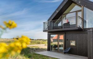 a house with a balcony and a chair on a deck at Ocean Front Home In Skagen With Wifi in Skagen