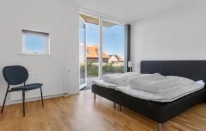 a bedroom with a bed and a chair and a window at Ocean Front Home In Skagen With Wifi in Skagen
