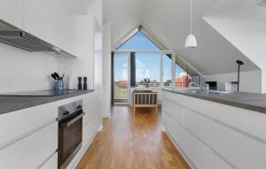 a kitchen with white counters and a large window at Ocean Front Home In Skagen With Wifi in Skagen
