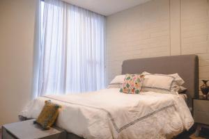メキシコシティにあるNew Apartment in CDMX: Experience the cityのベッドルーム1室(白いシーツ付きのベッド1台、窓付)