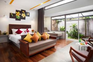 una camera da letto con un letto con cuscini gialli e rossi di The Calm Oasis a Siem Reap