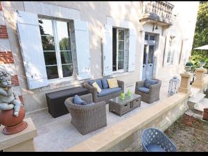 a patio with wicker chairs and a couch and tables at Gîte Rouffignac-Saint-Cernin-de-Reilhac, 6 pièces, 10 personnes - FR-1-616-141 in Rouffignac Saint-Cernin