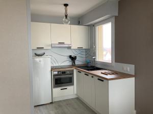uma cozinha com armários brancos e um frigorífico branco em Appartement Saint-Jean-de-Monts, 2 pièces, 4 personnes - FR-1-323-255 em Saint-Jean-de-Monts
