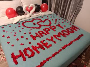 un pastel de cumpleaños con corazones encima de una cama en Hillview Inn Cameron Highlands PROMO, en Tanah Rata