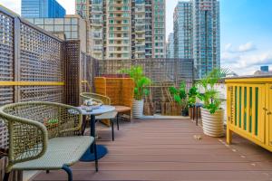 a balcony with tables and chairs and tall buildings at Lux Cabins Hotel Shenzhen in Shenzhen