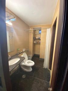 a bathroom with a white toilet and a sink at Independent Spacious Fully Furnished Room in House in Faridabad