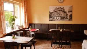 a restaurant with tables and chairs and a building on the wall at Hotel Restaurant Krone in Nassau
