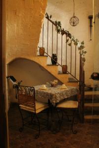 a table and chairs in a room with a staircase at I Visconti in Naples