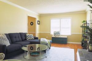 a living room with a blue couch and a glass table at The Cardinal Cape in High Point