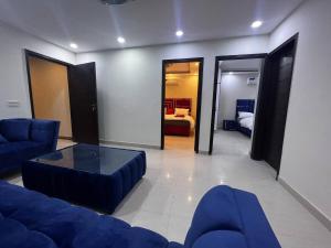 sala de estar con sofá azul y mesa en Hotline Apartments en Lahore